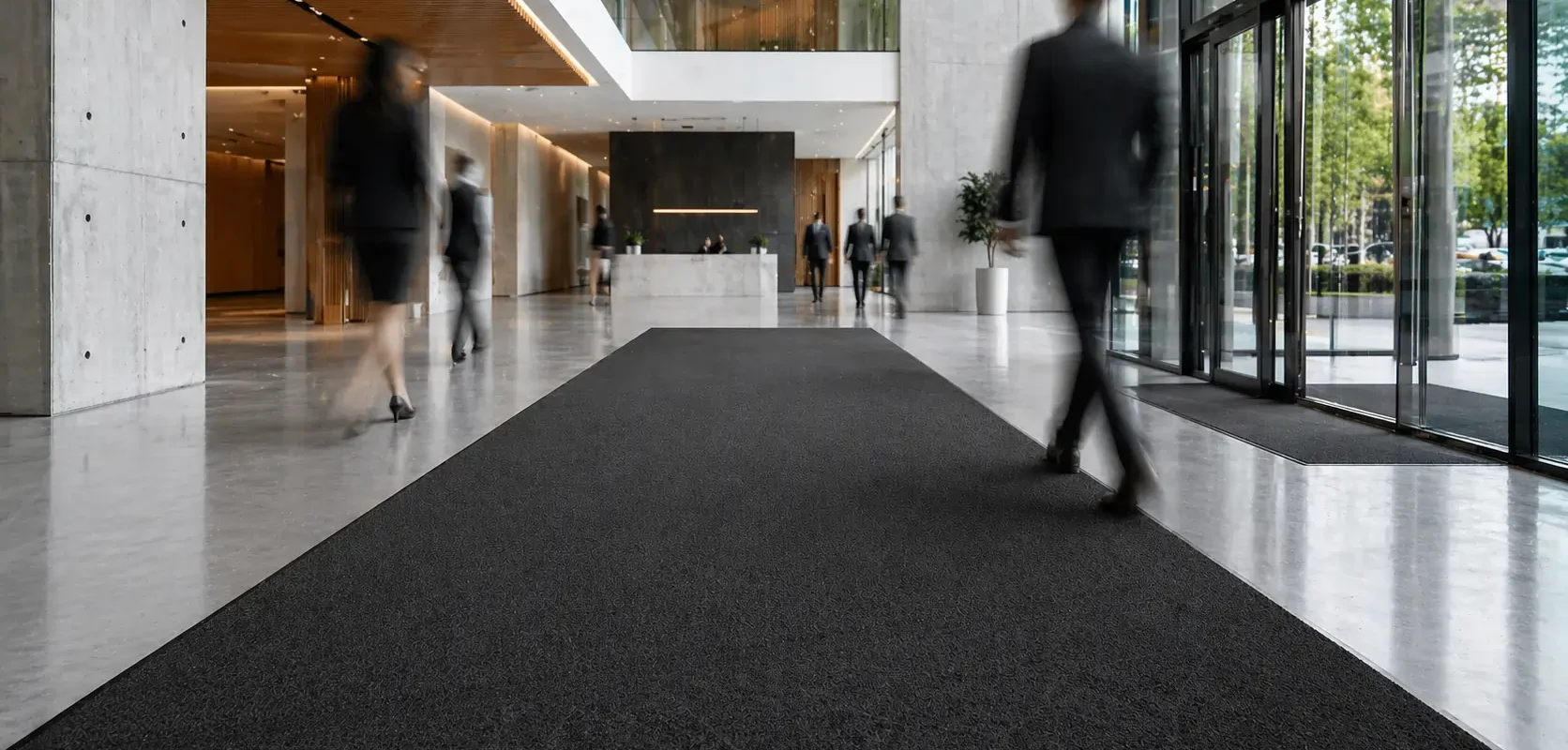 Hall d'entrée d'immeuble avec grand tapis d'accueil noir
